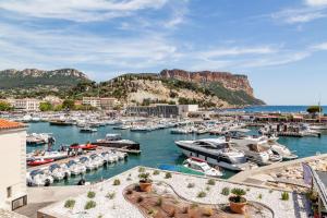 a group of boats in a marina with mountains in the background at Le Bel Ecrin par Dodo-a-Cassis in Cassis