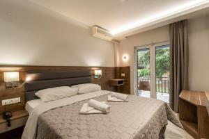 a bedroom with a large bed with towels on it at Sintrivanis Resort Beach in Paralía Skotínis +114 photos
