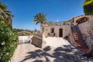 a house with a staircase and a palm tree at Villa Bing in Moraira