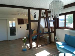 a living room with a blue couch and a chandelier at Die Galerie - Ferienwohnung in Merkendorf