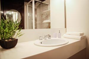 a bathroom with a sink and a mirror and a plant at Home & Pet - Fiori in Basiglio +22 photos