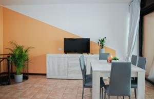 a dining room with a table and a tv at Home & Pet - Fiori in Basiglio
