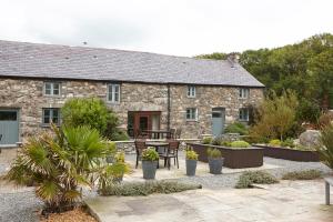 una casa de piedra con un patio frente a ella en The Cottage Llyn Peninsula, en Nefyn