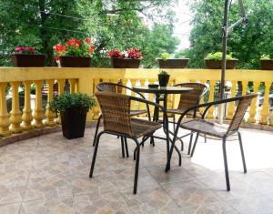 a patio with three chairs and a table and a fence at Smeštaj Olivera Niška Banja in Niška Banja