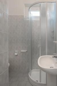 uma casa de banho branca com um chuveiro e um lavatório. em Hotel Sole Mio em Rimini