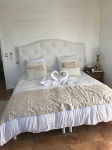 ein großes weißes Bett mit weißem Band darauf in der Unterkunft villa santa rita in Auribeau-sur-Siagne