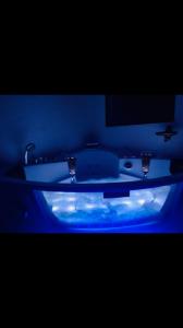 ein Badezimmer mit einer Badewanne mit blauem Licht in der Unterkunft villa santa rita in Auribeau-sur-Siagne