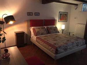 een slaapkamer met een bed en twee tafels en een lamp bij Il Giardino Segreto in Carbognano