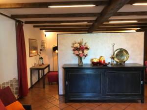 una habitación con un armario negro con un jarrón de flores en Il Giardino Segreto, en Carbognano