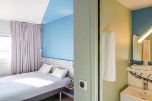 Cette petite chambre comprend un lit et un lavabo. dans l'établissement Ibis Budget Aubenas, à Aubenas