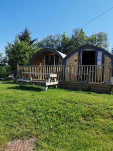 a large circular cabin with a bench in the grass at Tigh Beag na h'aibhne in Broadford