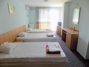 a hotel room with three beds and a window at Hostel Papagal in Varna City +84 photos