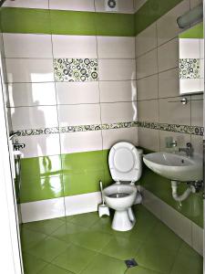 a green and white bathroom with a toilet and sink at "Бербатови 1" in Ravda