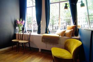 a room with a window with chairs and a table at 1637: Historic Canal View Suites in Amsterdam