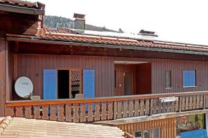 una casa con terrazza in legno e portico di Ferienwohnung Del Toso a Schliersee