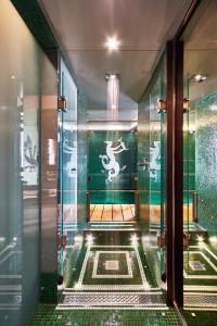 uma casa de banho com um chuveiro e piso em azulejo verde em Hotel Saturnia & International em Veneza