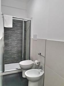 a white bathroom with a toilet and a sink at Blu Maris Acqua in Marina di Ragusa