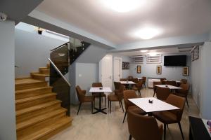 a dining room with tables and chairs and stairs at Eagles Philadelphia in Korçë