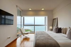 1 dormitorio con cama grande y ventana grande en InkaHuset Miraflores Oceanfront, en Lima