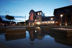 a large building with a pond in front of it at Hotel Skjern in Skjern