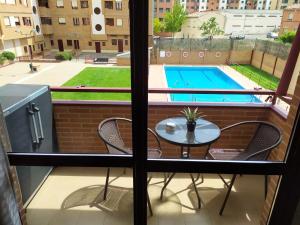 a balcony with a table and chairs and a swimming pool at Estudio Bellavista in Logroño