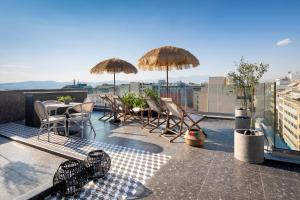 a patio with chairs and umbrellas on a roof at The Pinnacle Athens in Athens