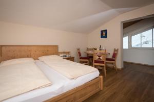 een slaapkamer met een bed en een tafel met stoelen bij Appartementhaus Christophorus in Obertauern