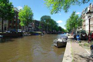 a city street filled with lots of parked boats at 1637: Historic Canal View Suites in Amsterdam