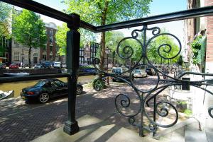 a bike parked next to a fence on a sidewalk at 1637: Historic Canal View Suites in Amsterdam