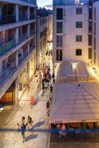 uma multidão de pessoas andando em uma rua entre edifícios em Downtown Marcius Luxury Apartment with Jacuzzi & Sauna em Zadar