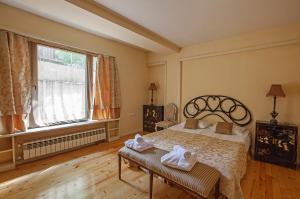 a bedroom with a bed and a large window at Caravan Villa in Tbilisi City
