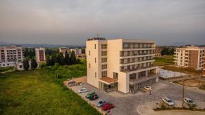 a large white building with cars parked in a parking lot at HOTEL FRANCA ULCINJ in Ulcinj