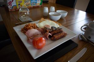 ein Teller mit Fleisch und Gemüse auf dem Tisch in der Unterkunft Drumlochy B&B in Inverness