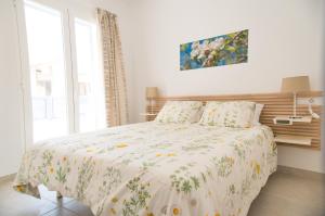 カラ・ラトハダにあるCa sa Padrina Barruanaのベッドルーム1室(花柄の掛け布団付きのベッド1台付)