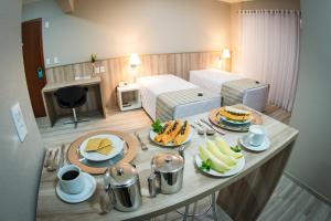 una stanza d'albergo con un tavolo con del cibo sopra di Aquarius Hotel Flat Residence a Santa Cruz do Sul