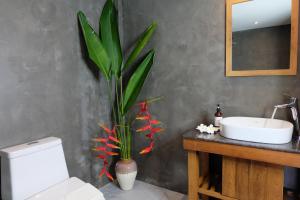 ein Badezimmer mit einem WC, einem Waschbecken und einer Pflanze in der Unterkunft Koh Ma Beach Resort - SHA Extra Plus in Mae Haad