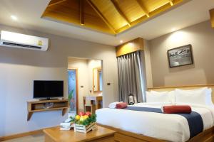ein Schlafzimmer mit großem Bett und Fernseher in der Unterkunft Koh Ma Beach Resort - SHA Extra Plus in Mae Haad