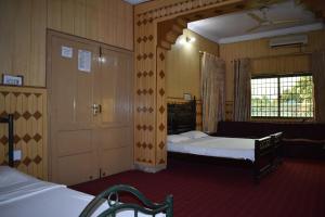 a hotel room with two beds and a door at Paramid II in Islamabad