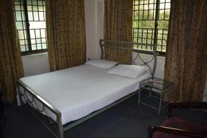 a bed in a room with two windows at Paramid II in Islamabad