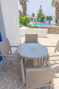 a patio with a table and chairs and a pool at Fragoulis Village in Parasporos