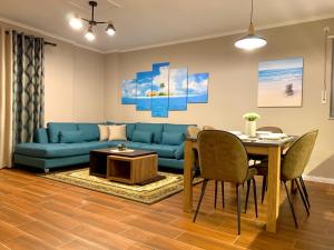 a living room with a blue couch and a table at EKA Luxury Two-Bedroom Premium Apartment 2 in Durrës +10 photos