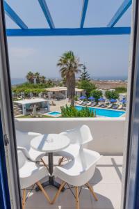 einen Blick vom Balkon eines Resorts mit einem Tisch und Stühlen in der Unterkunft Fragoulis Village in Parasporos