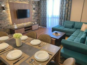 a living room with a table and a blue couch at EKA Luxury Two-Bedroom Premium Apartment 2 in Durrës