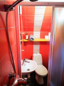 a red bathroom with a toilet and a sink at Beltes Guest House in Jūrmala