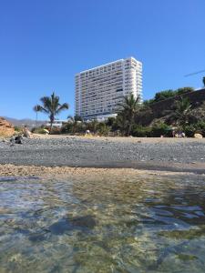 ein großes Gebäude am Strand mit dem Wasser in der Unterkunft Paraiso 12 - 1bedroom in Playa Paraiso