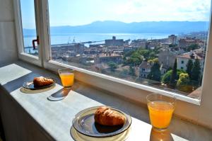 dois bolos num balcão com sumo de laranja e uma janela em Sentona Apartment em Rijeka
