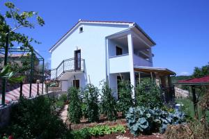 una casa con un jardín delante de ella en Villa Roze, en Čižići