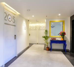 a hallway with a blue table and a mirror at Centro in Pune