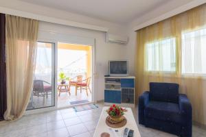 a living room with a couch and a tv and a table at Shark Apartments in Skala Potamias