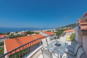 a balcony with a table and chairs and the ocean at Apartments Naja - Makarska Exklusiv in Makarska